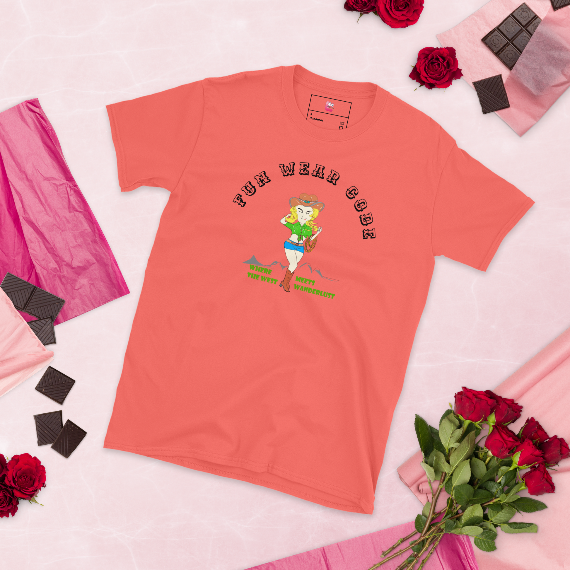 Coral t-shirt with a graphic design of a cowgirl and text " FUN WEAR CODE" on a pink background with roses and chocolate.