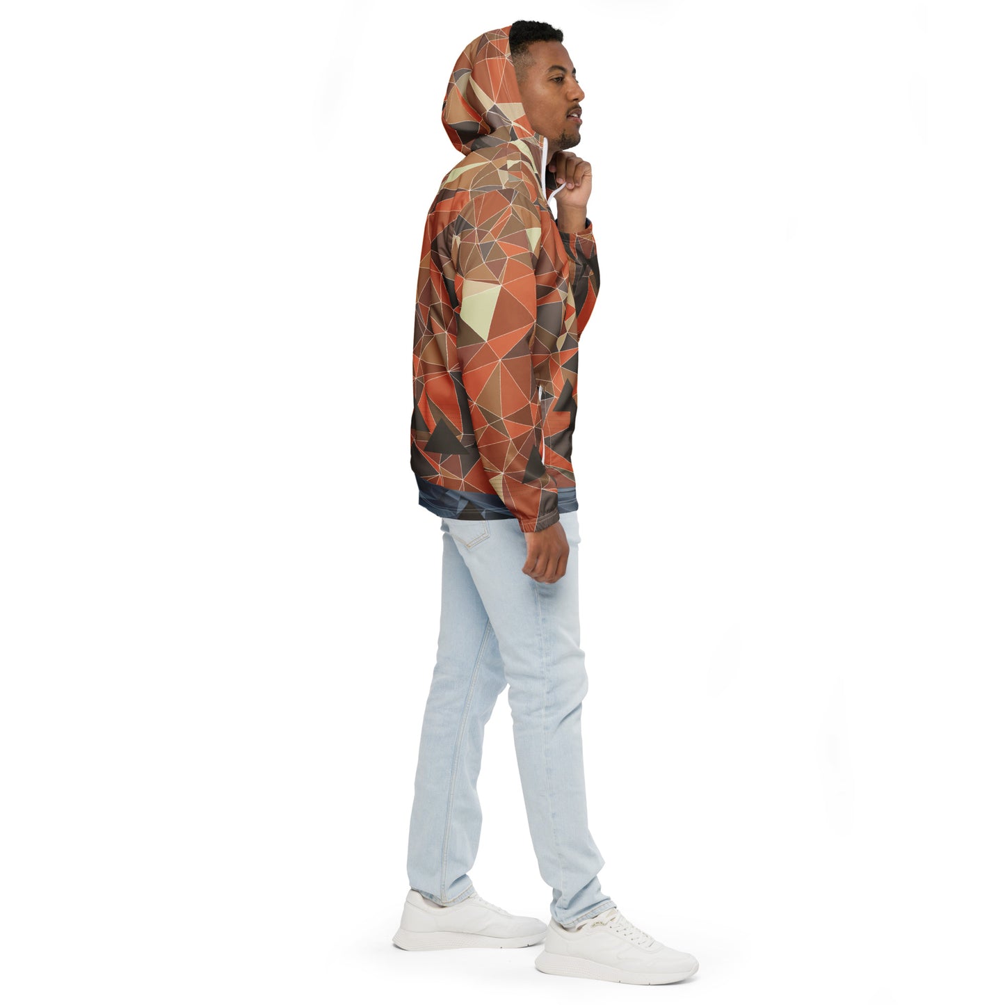 Person wearing a multicolor geometric patterned windbreaker jacket on a white background