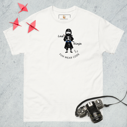 White t-shirt with a playful ninja graphic design and text "Last Ninja - FUN WEAR CODE", placed on a textured surface with a camera and origami birds.